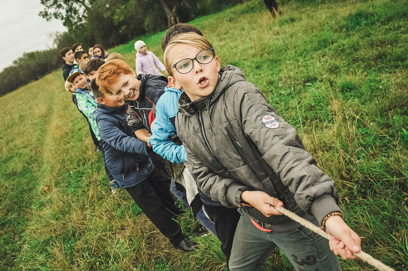 Group of boys playing tug of war outdoors