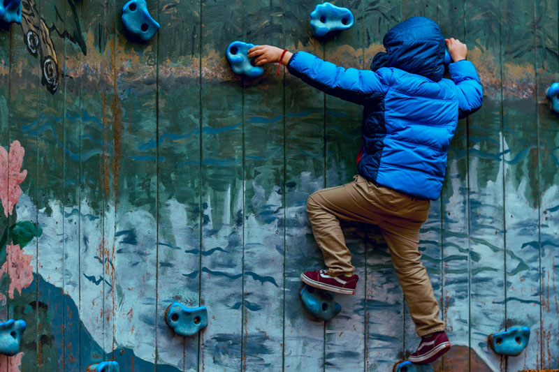 Young boy enjoying physical activity on a climbing wall